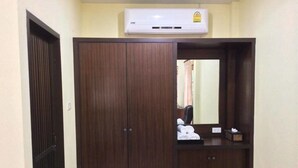 A room with a wardrobe, a mirror, and an air conditioning unit. - Ron's Bungalow (Choeng Thale)