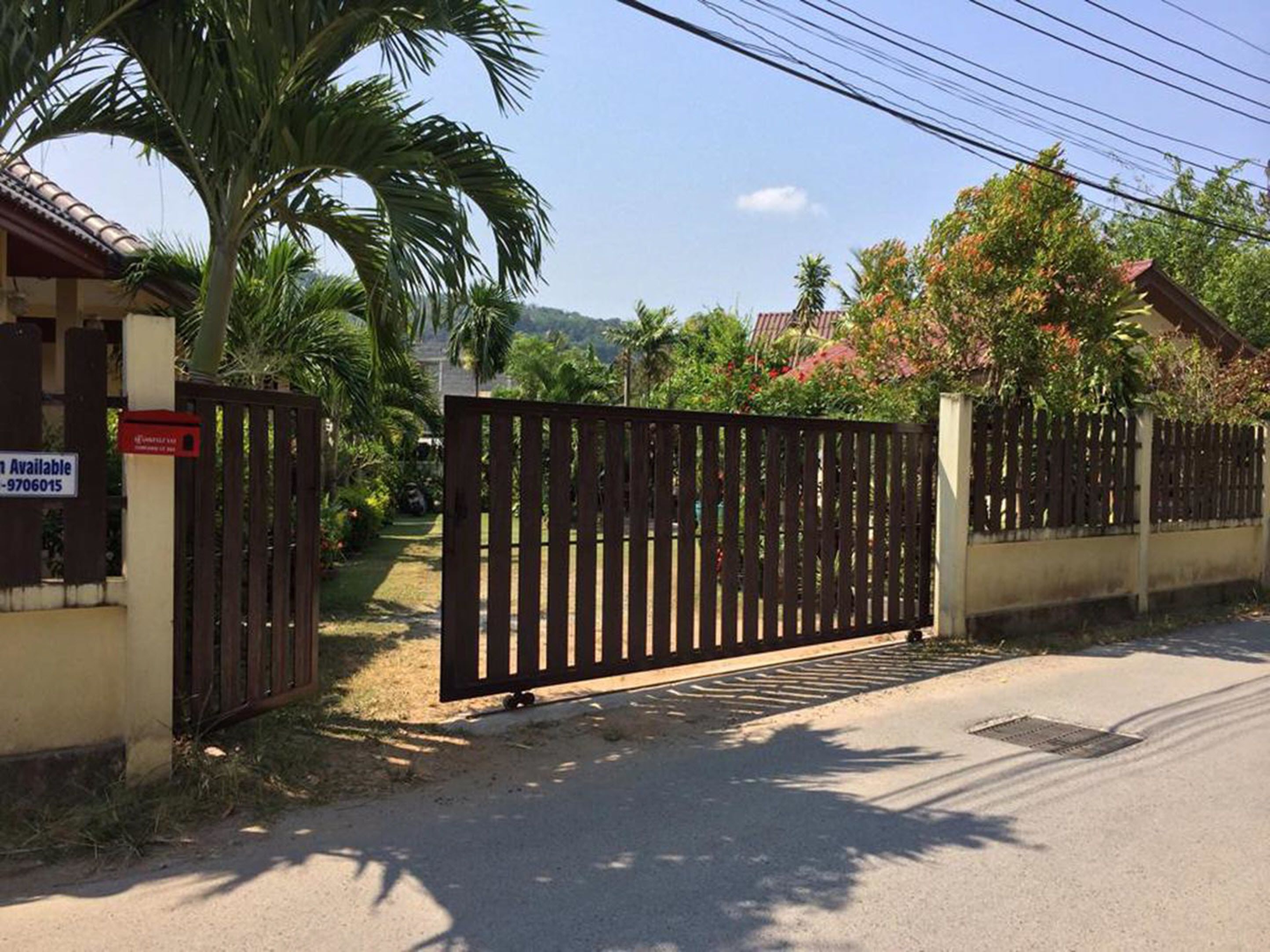 A gated entrance with a sign indicating availability and a contact number.