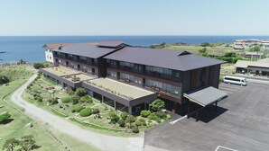 Un hôtel moderne à plusieurs étages, doté d’un jardin sur le toit et d’un espace de stationnement.