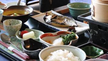 Eine traditionelle japanische Mahlzeit mit verschiedenen Gerichten, darunter Reis, Fisch und Gemüse.