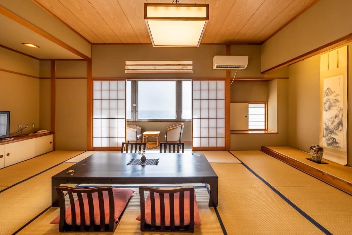 A traditional Japanese room with tatami flooring, a low table, and shoji screens.