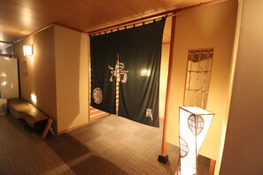 A traditional Japanese room with tatami flooring, a shoji screen, and a low wooden bench. - Sado Resort Hotel Azuma (Sado)