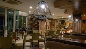 Ein modernes Restaurant-Interieur mit hohen Tischen, bequemen Stühlen und einzigartigen, geometrischen Pendelleuchten.