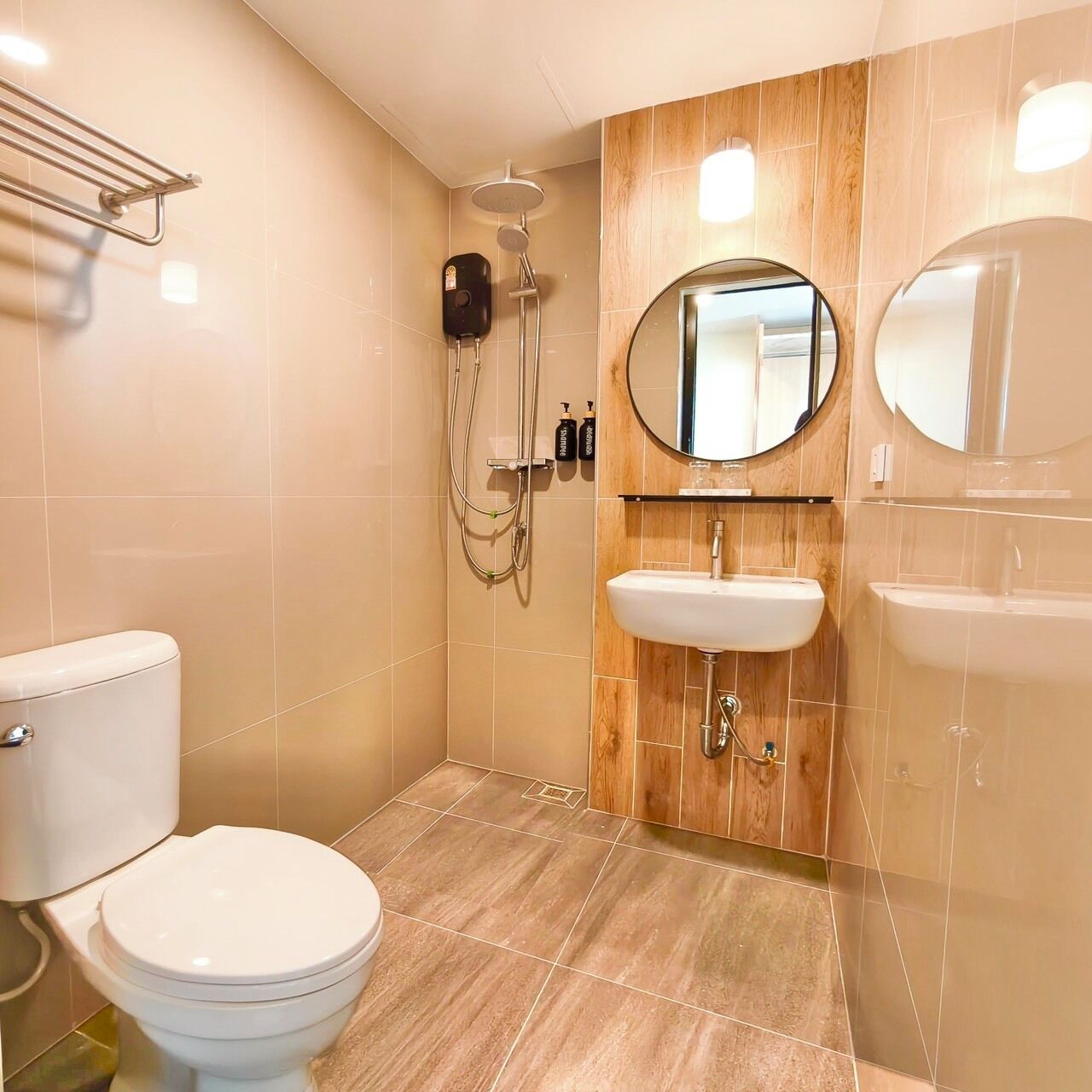 Un baño moderno con inodoro, ducha y dos lavamanos.