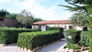 A house with a tiled roof, surrounded by well-maintained hedges and a gravel path. - L'Araucaria (Santa Croce Camerina)