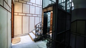 A modern interior with a staircase, a doormat, and a glass elevator. - Family Affair (Palermo)