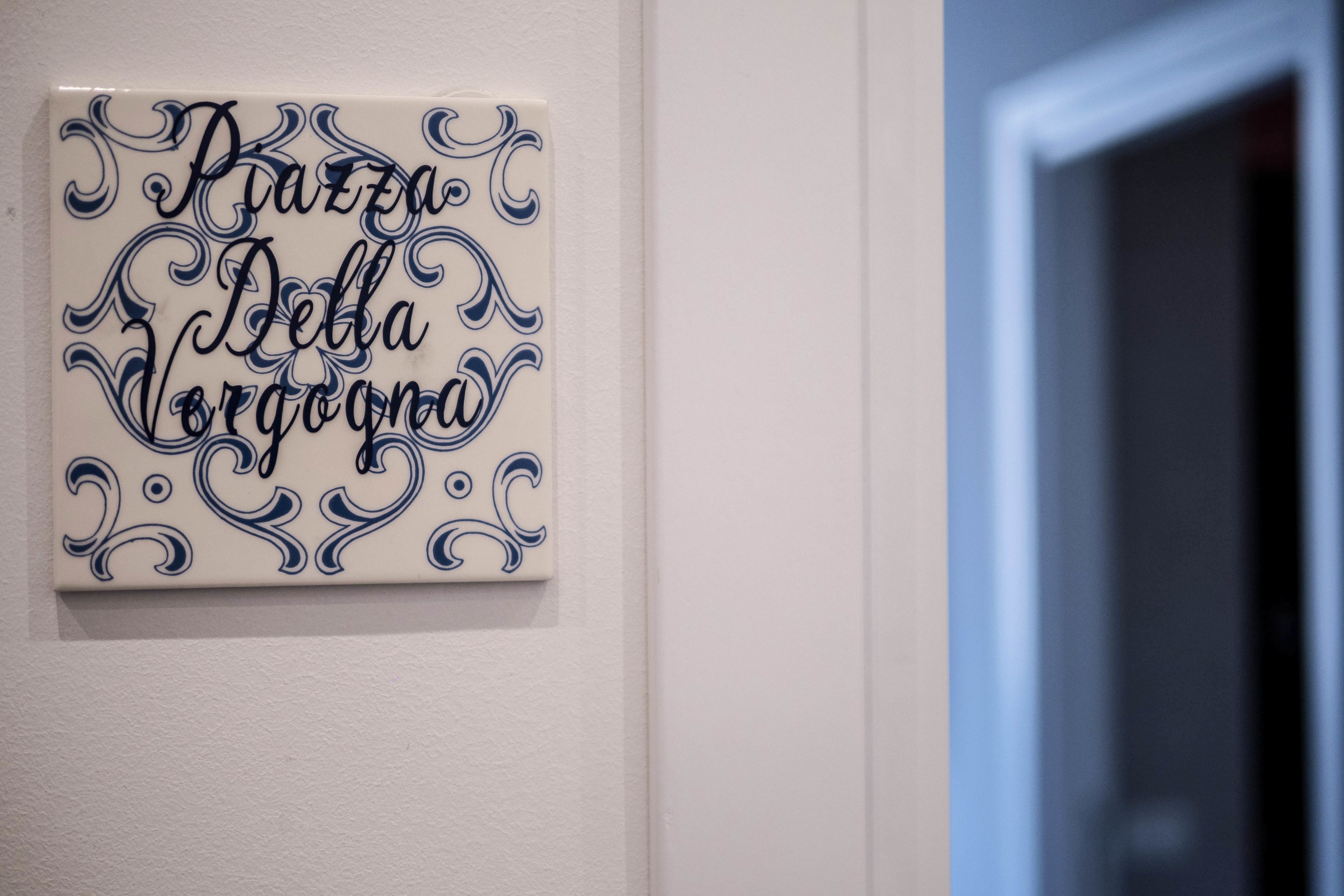 A wall with a decorative tile featuring cursive text.