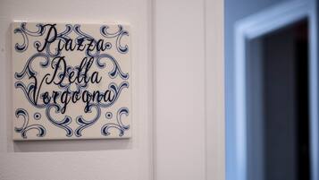 A wall with a decorative tile featuring cursive text.