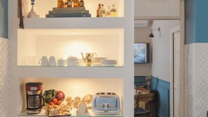 A kitchen with a coffee maker, toaster, and various kitchen items on shelves. - Family Affair (Palermo)