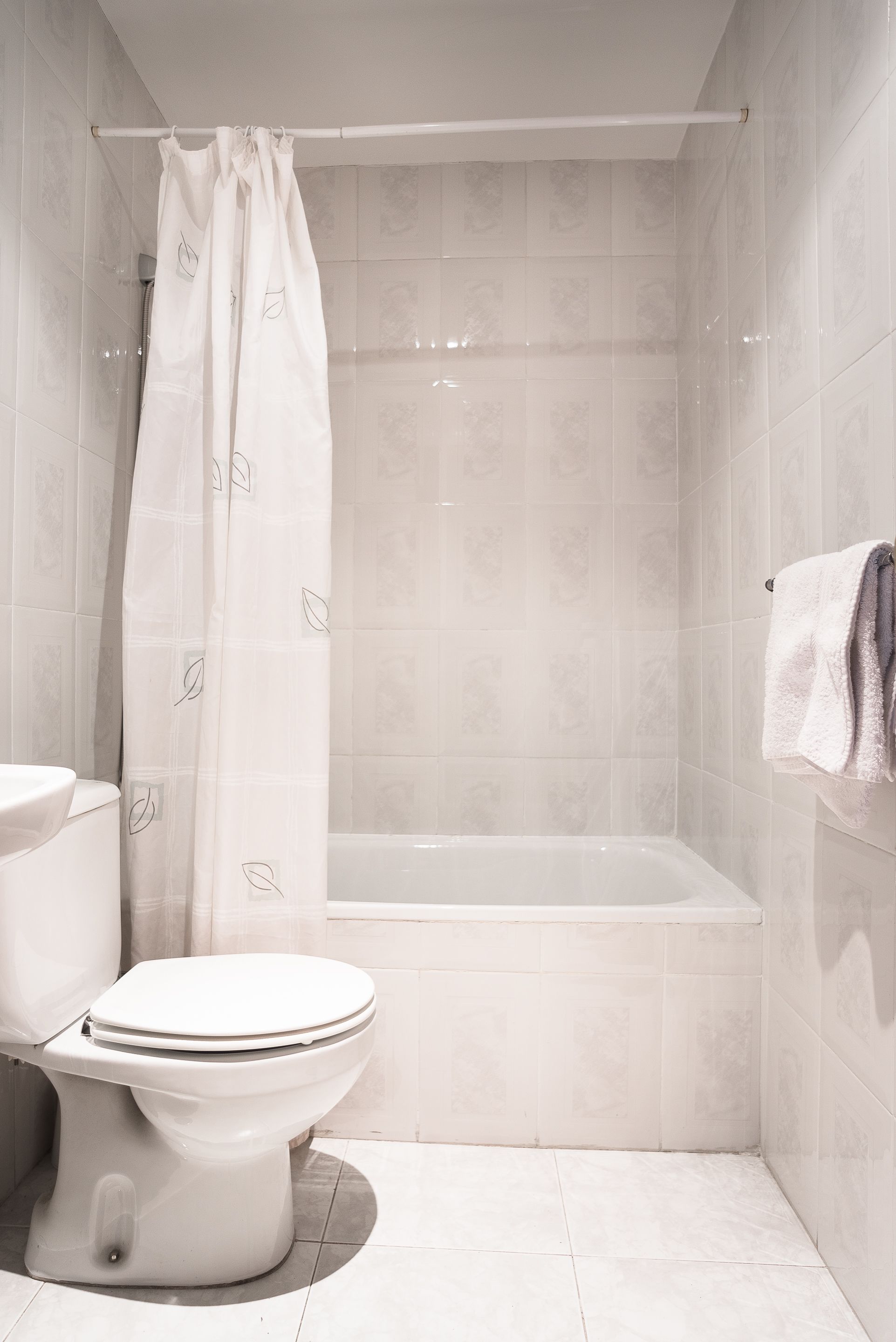 Un baño con inodoro, bañera y cortina de ducha.