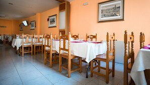 A dining area with multiple tables and chairs, arranged in rows. - Hostal del Campo (Arévalo)