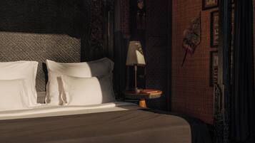 A bedroom with a large bed, a nightstand, and a lamp.