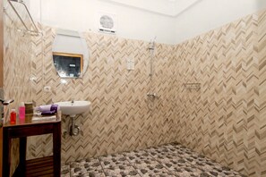 Standaard driepersoonskamer | Badkamer | Een douche, gratis toiletartikelen, een haardroger, handdoeken