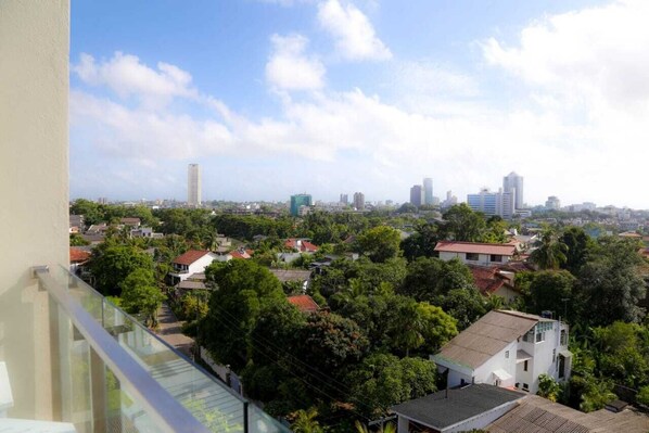 Een woongebied met een combinatie van huizen en hoogbouw, een heldere lucht en een balkon met uitzicht.