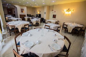 A dining area with round tables set for four, each with white tablecloths, plates, cutlery, and glasses. - Hotel Le Fonti (Montecatini Terme)