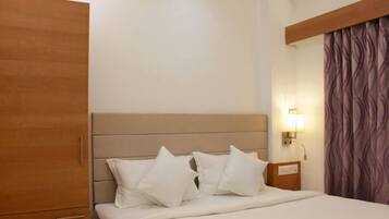A hotel room with a bed, a nightstand, a lamp, and a wardrobe.