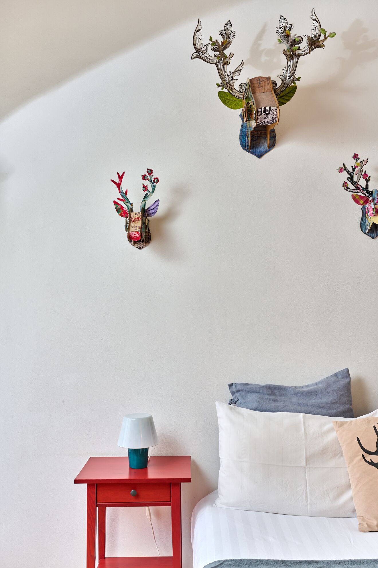 Une chambre à coucher comprenant un lit, une table de chevet et des œuvres d’art décoratives au mur.
