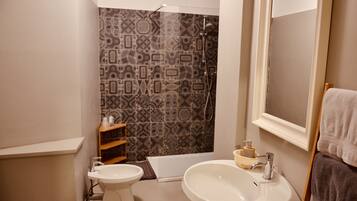 Ein Badezimmer mit Toilette, Bidet, Badewanne und Waschbecken.