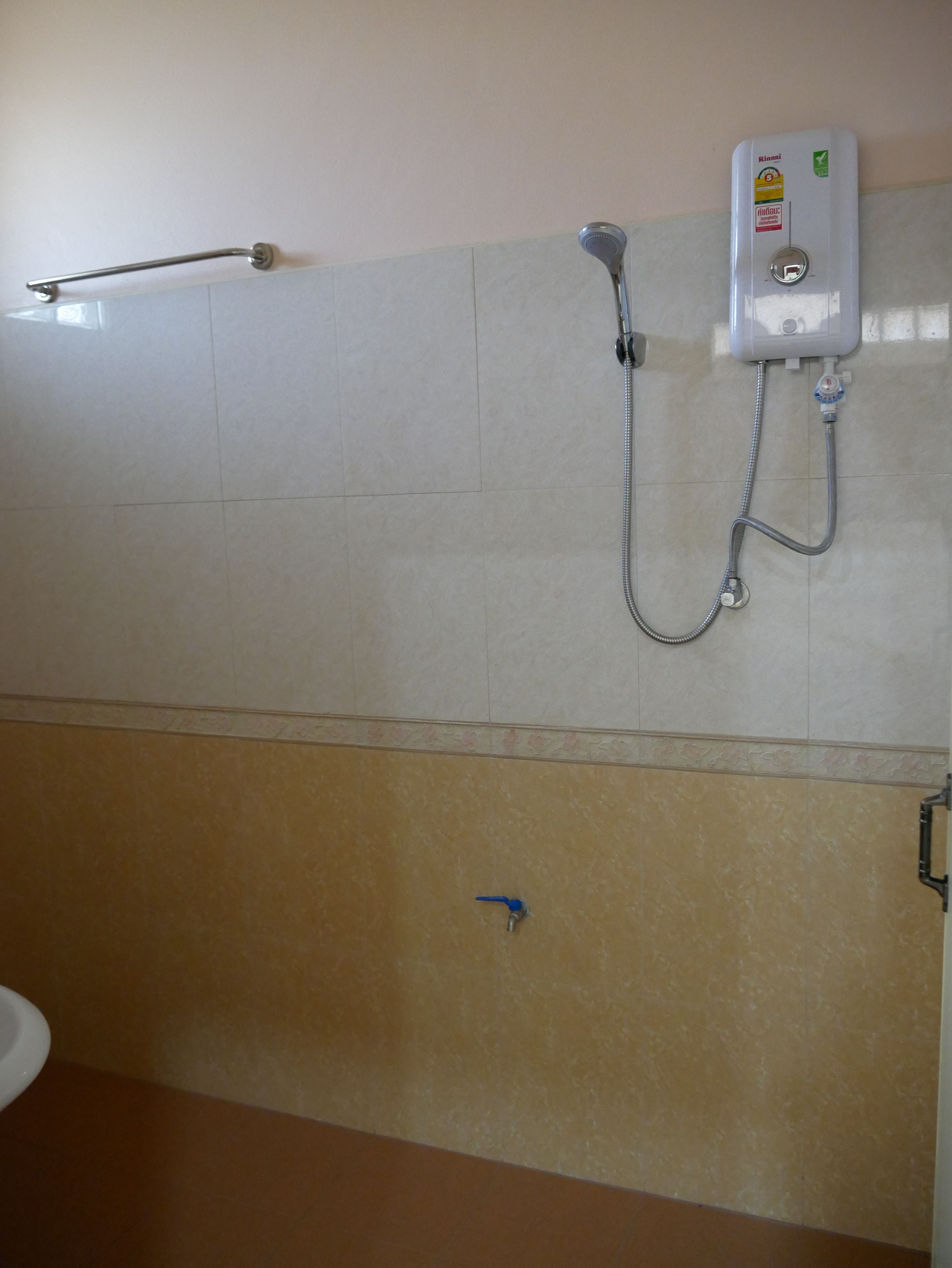 Un baño con ducha, inodoro y toallero.
