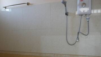 Un baño con ducha, inodoro y toallero.