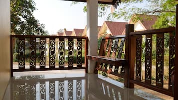 A covered balcony with a reflective floor and decorative metal railings.