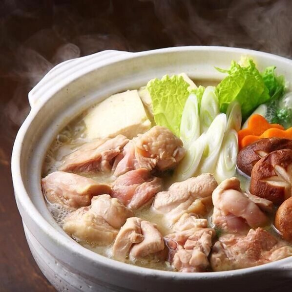 A bowl of soup with chicken, vegetables, and tofu.