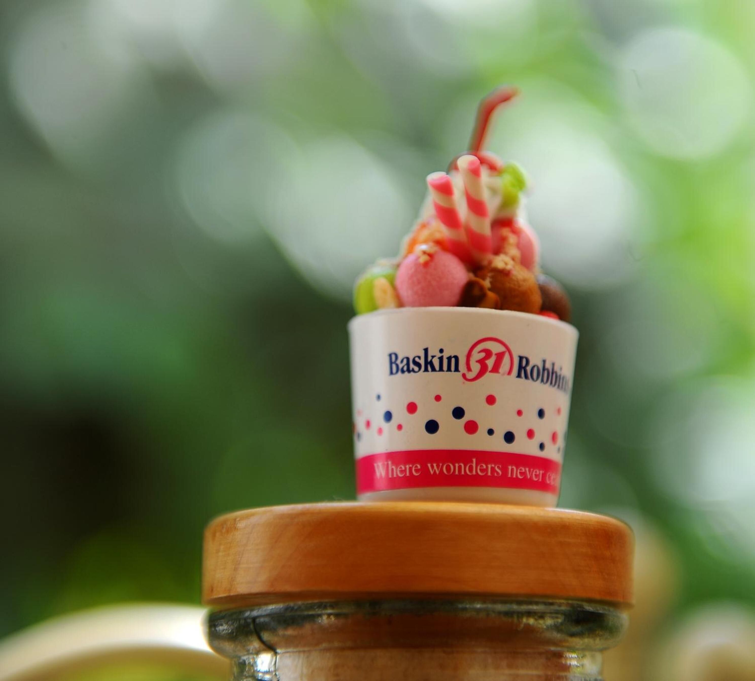 A dessert cup with a wooden lid, labeled "Baskin Robbins" and "Where wonders never cease."
