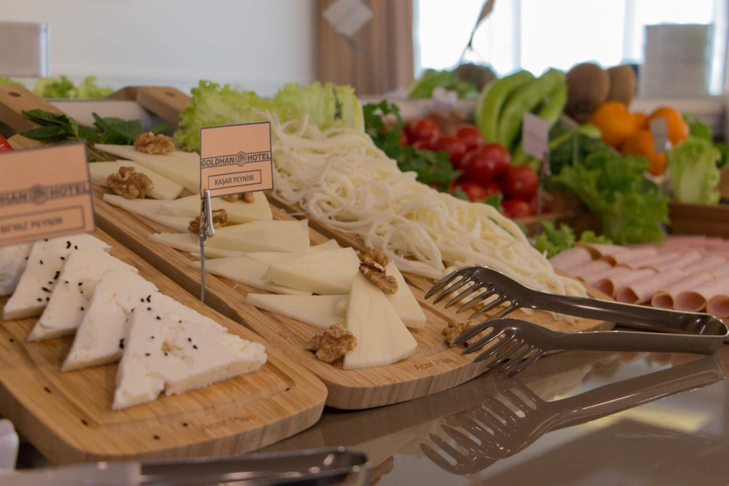 A buffet with various cheeses, nuts, and vegetables.