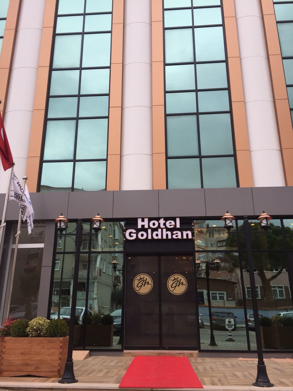 L'entrée de l'hôtel Goldhan, avec un tapis rouge et un drapeau.