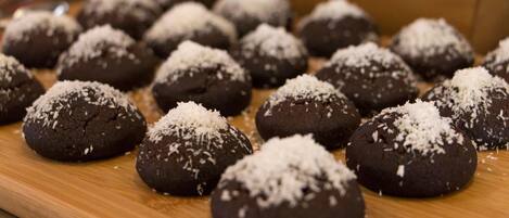 A tray of chocolate cookies with coconut shavings.