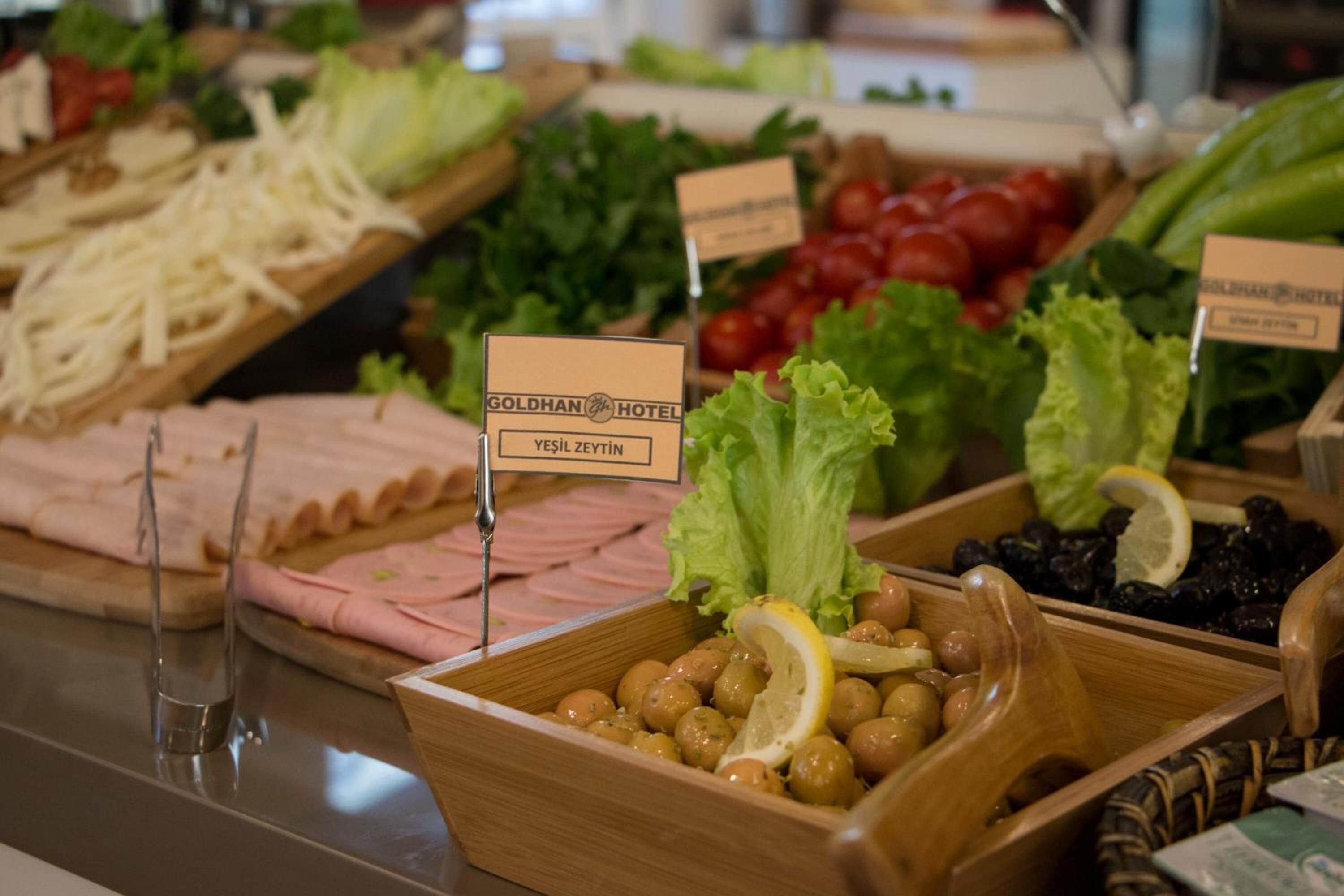 A buffet with various food items including meats, cheeses, and vegetables.