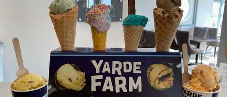 Presentación de cucuruchos y tarrinas de helado en Yarde Farm, con un cartel que dice 'Nos tomamos el helado en serio'.