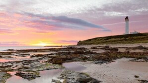 A coastal landscape with a lighthouse, rocky shore, and a sunset. - Golf View Hotel (Lossiemouth)