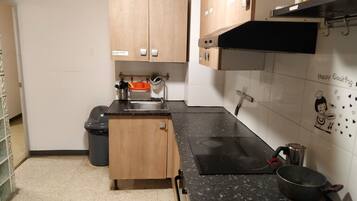 Refrigerador em uma área comum, micro-ondas em uma área comum, cooktop