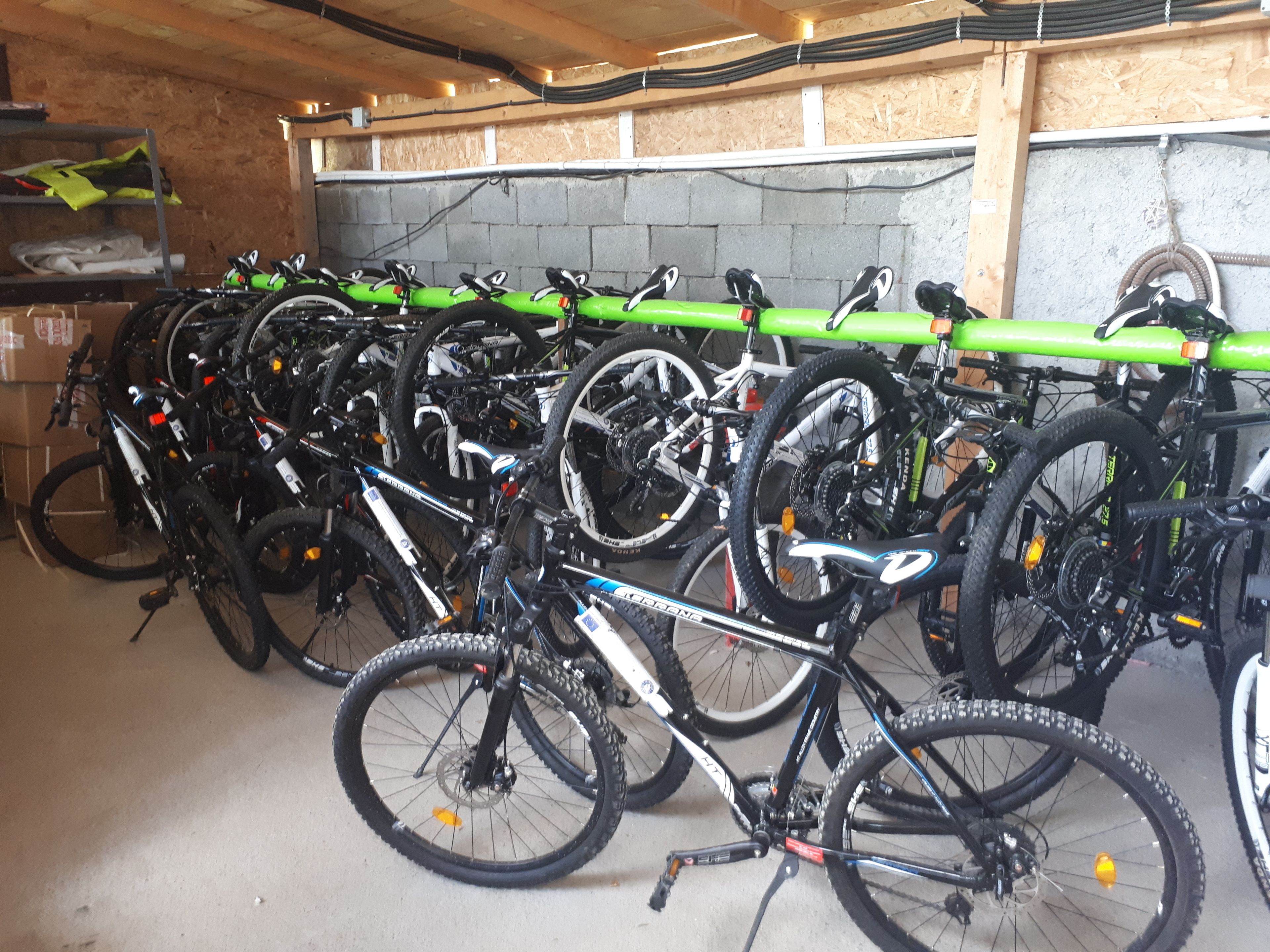 A bike storage area with multiple bicycles parked against a wall.