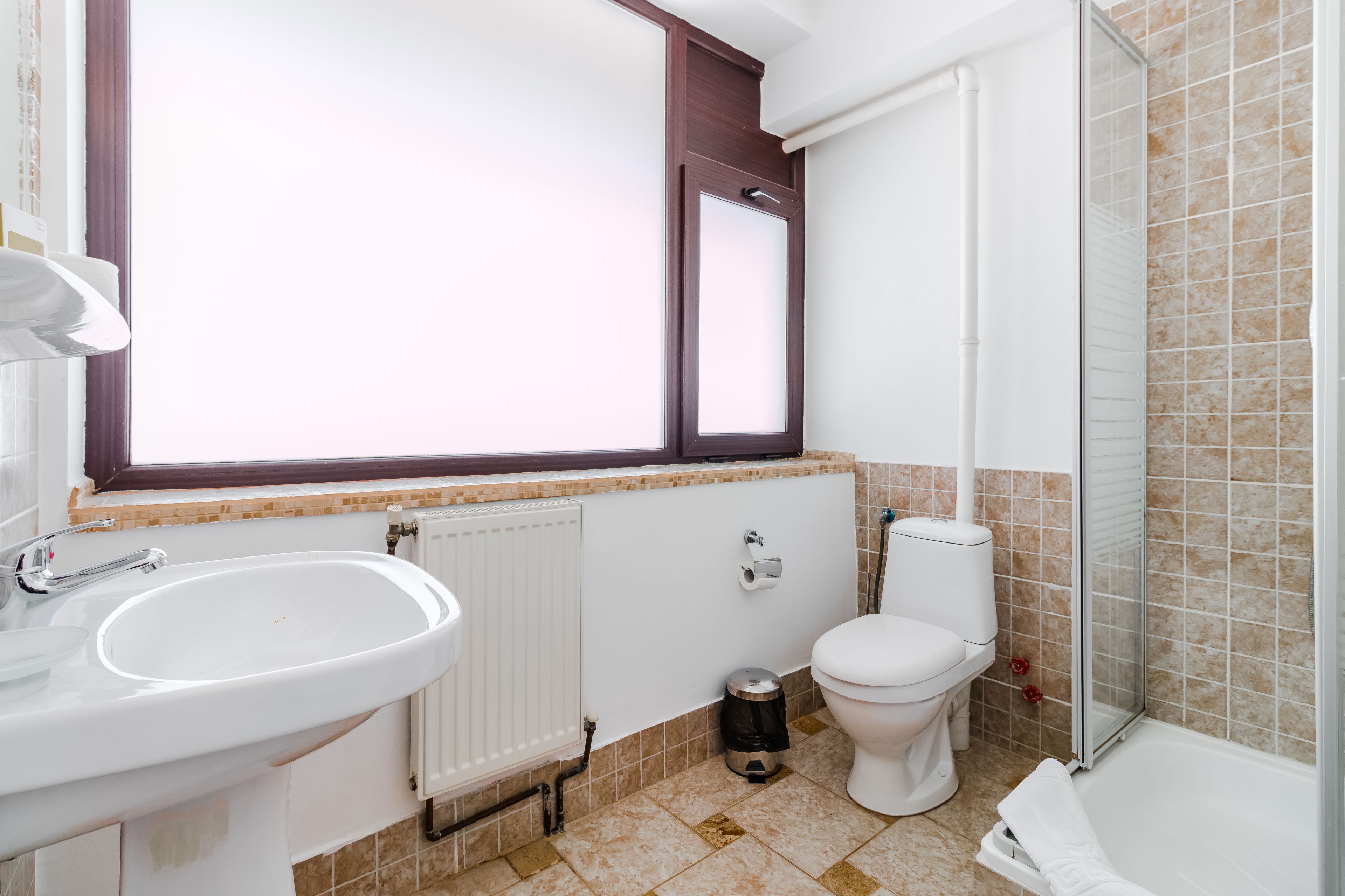 Een badkamer met wastafel, toilet en douche.