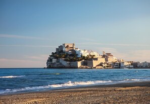 Un pueblo costero con una imponente estructura que recuerda a un castillo, situada sobre un promontorio rocoso y con vistas al mar.