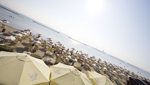 A beach with rows of umbrellas and lounge chairs. - Residence Long Beach Village (Ravenna)