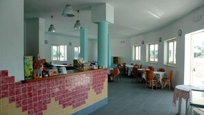 A spacious dining area with high ceilings, pendant lighting, and large windows. - Residence Long Beach Village (Ravenna)