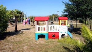 A children's play area with a colorful train structure and slides. - Residence Long Beach Village (Ravenna)