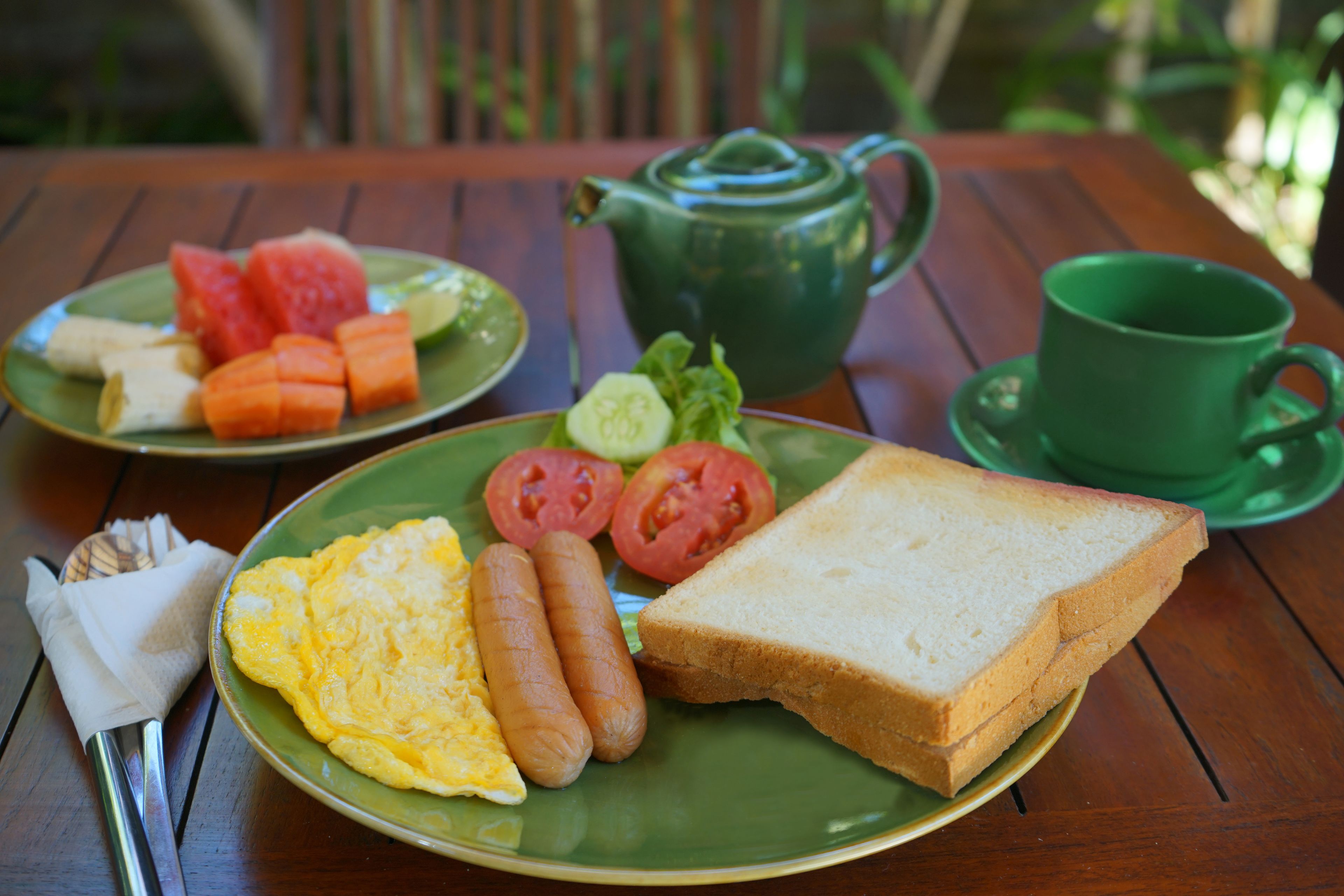 Una mesa con platos de comida, una tetera y una taza.