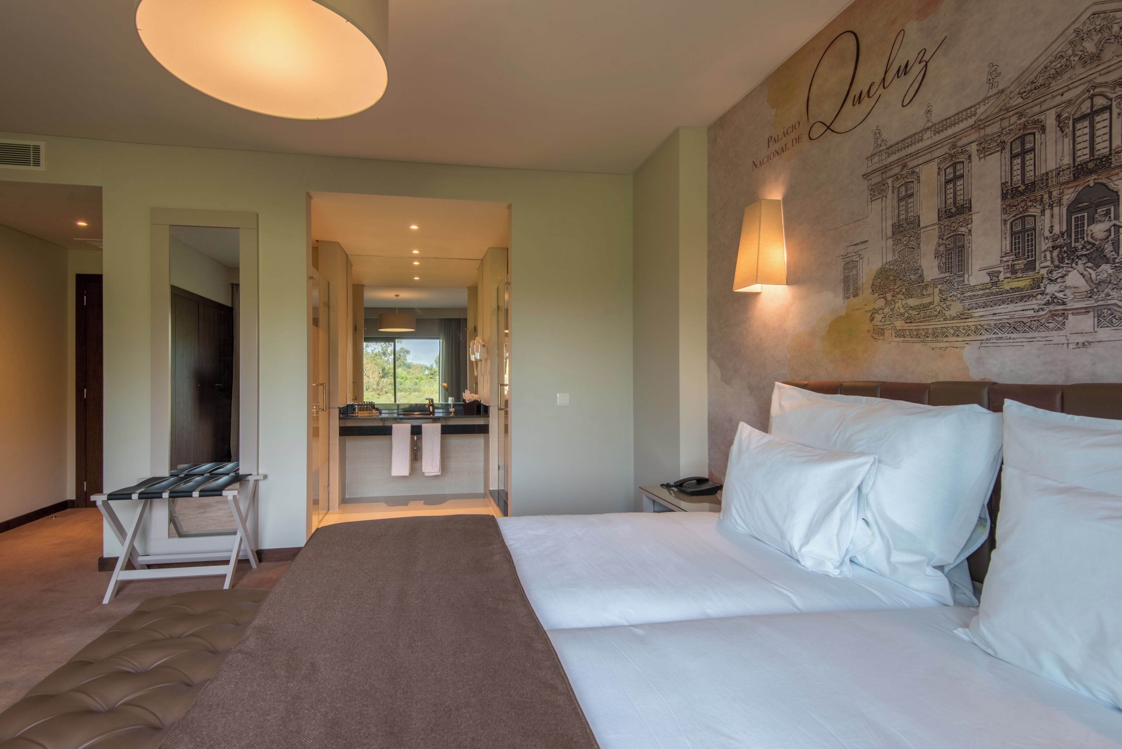 Ein Hotelzimmer mit einem Bett, einem Schreibtisch und einem durchgegangenen Tür erkennbaren Badezimmer.