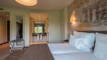 Ein Hotelzimmer mit einem Bett, einem Schreibtisch und einem durchgegangenen Tür erkennbaren Badezimmer.