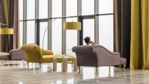 A spacious lobby with large windows, modern furniture, and a polished floor.
