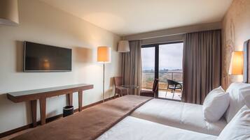 Una habitación de hotel con dos camas, un televisor, un escritorio y una silla.