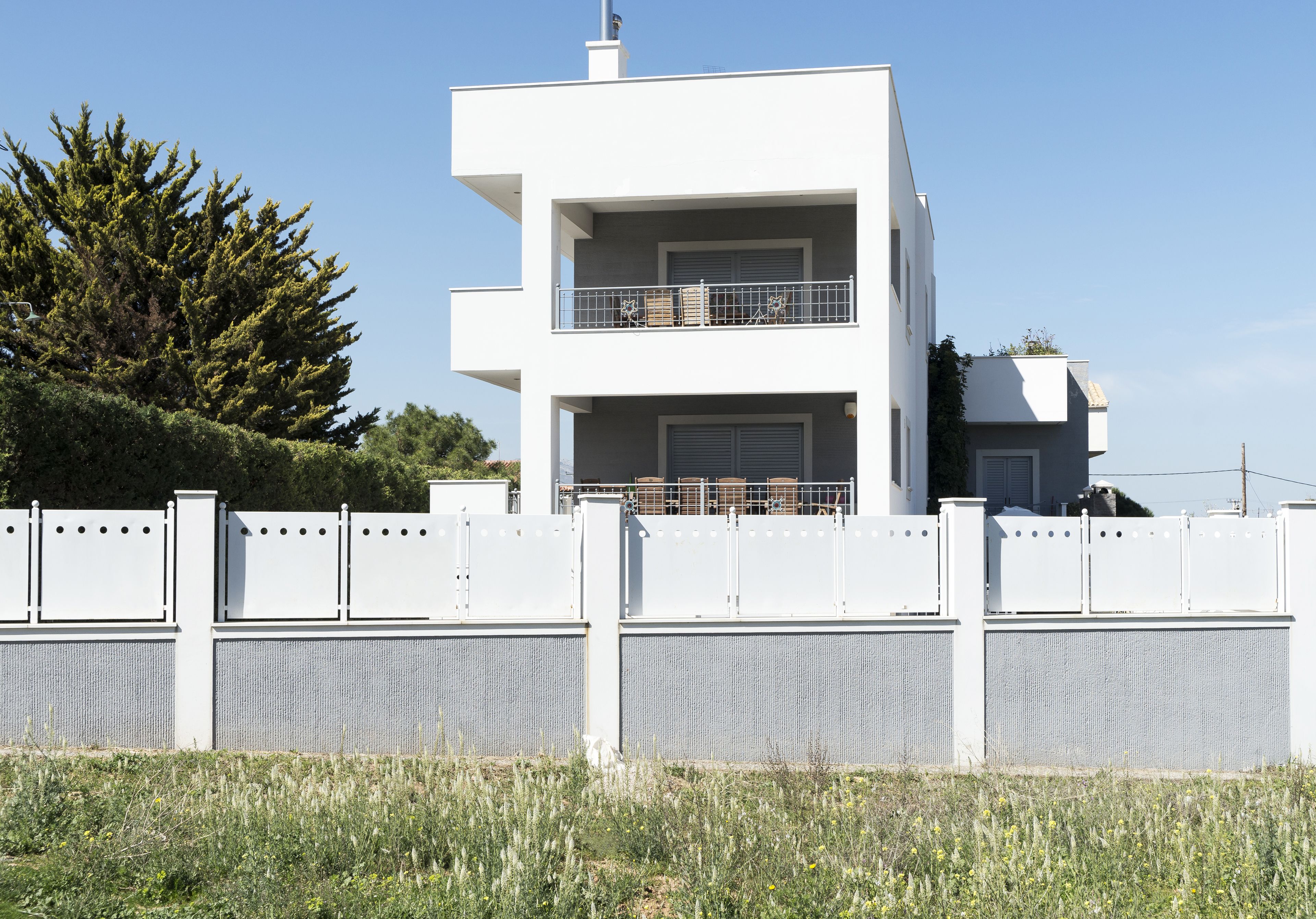 A modern two-story building with a balcony on the upper floor.