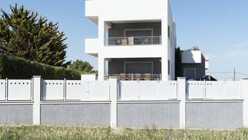 A modern two-story building with a balcony on the upper floor.