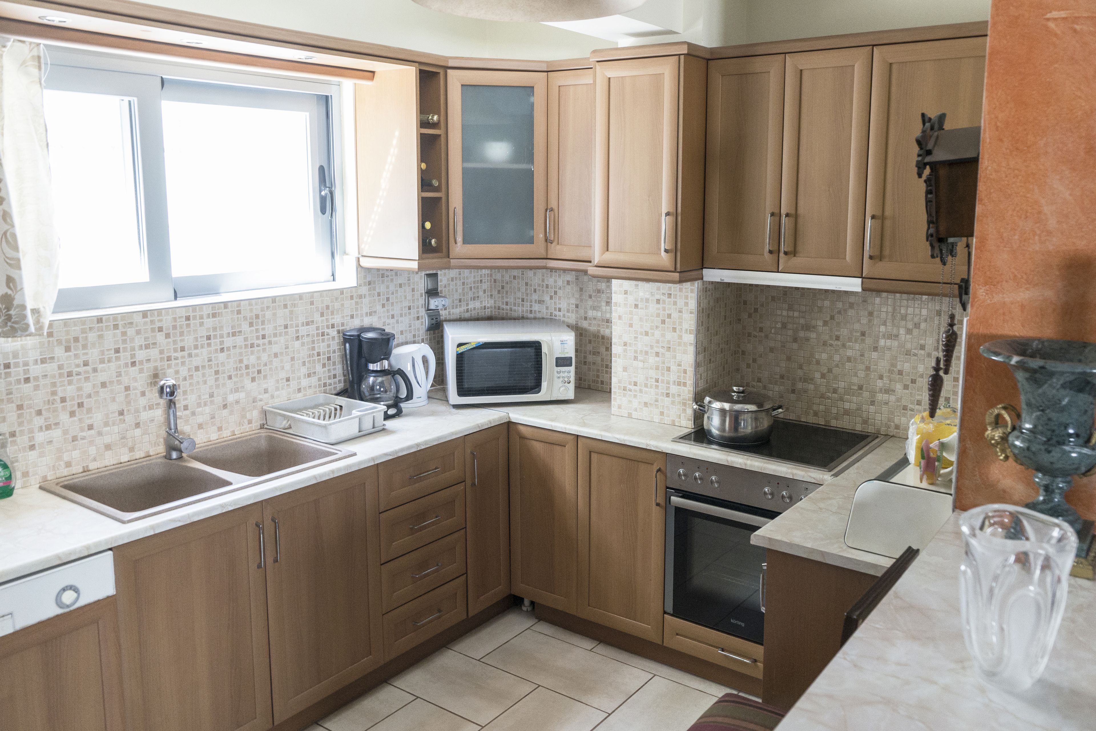A kitchen with wooden cabinets, a microwave, a sink, and a stove.