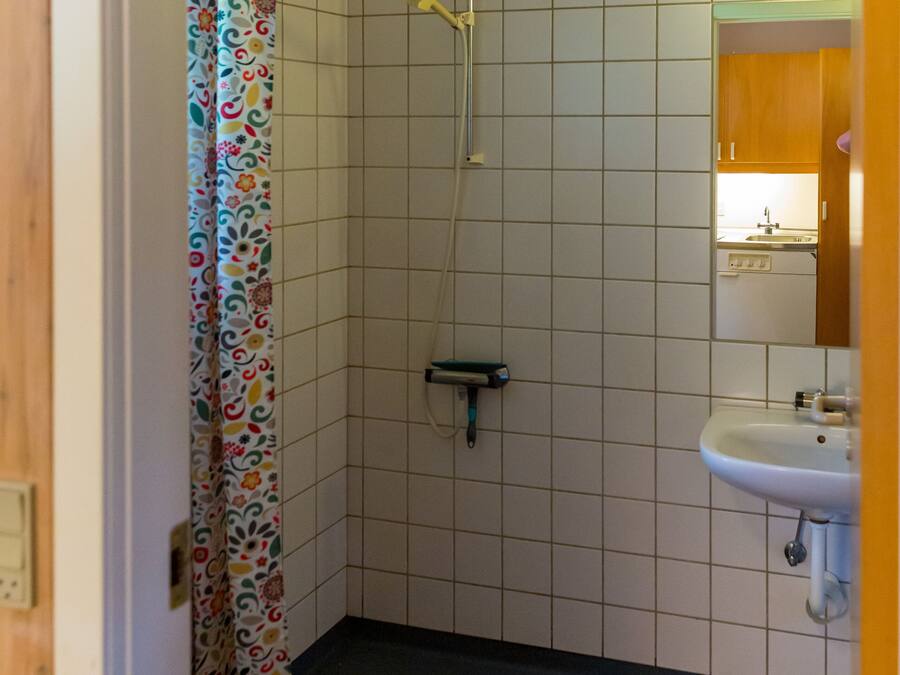 Baño con ducha, inodoro y lavamanos.