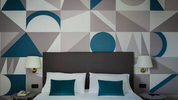 Ein Hotelzimmer mit einem großen Bett, zwei Nachttischen und einer Wand mit geometrischen Mustern.